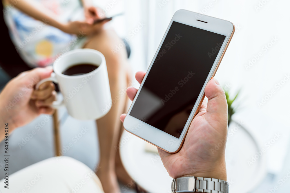 Hand holding smartphone mockup of blank screen on the table. Take your screen to put on advertising. Hand holding smartphone mockup of blank screen on the table. Take your screen to put on advertising.