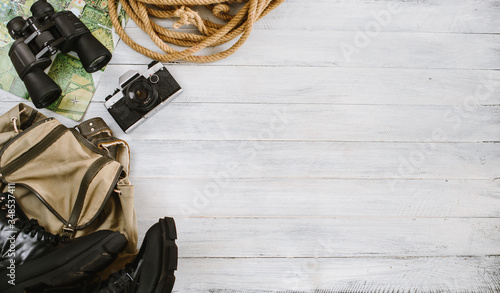 Top view of travel accessories for a mountain trip on white wooden background, flatlay, copy space