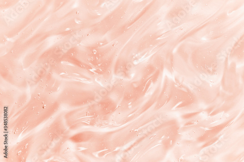 Hyaluronic acid serum texture. Skin care liquid gel background. Clear shiny pink beauty product with bubbles sample photo