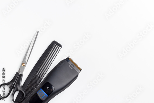 hair clipper, scissors and comb on a white background