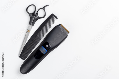 hair clipper, scissors and comb on a white background