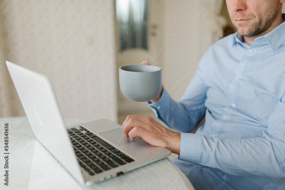 A man in blue shirt with notebook and cup of coffee A man in blue shirt with notebook and cup of coffee