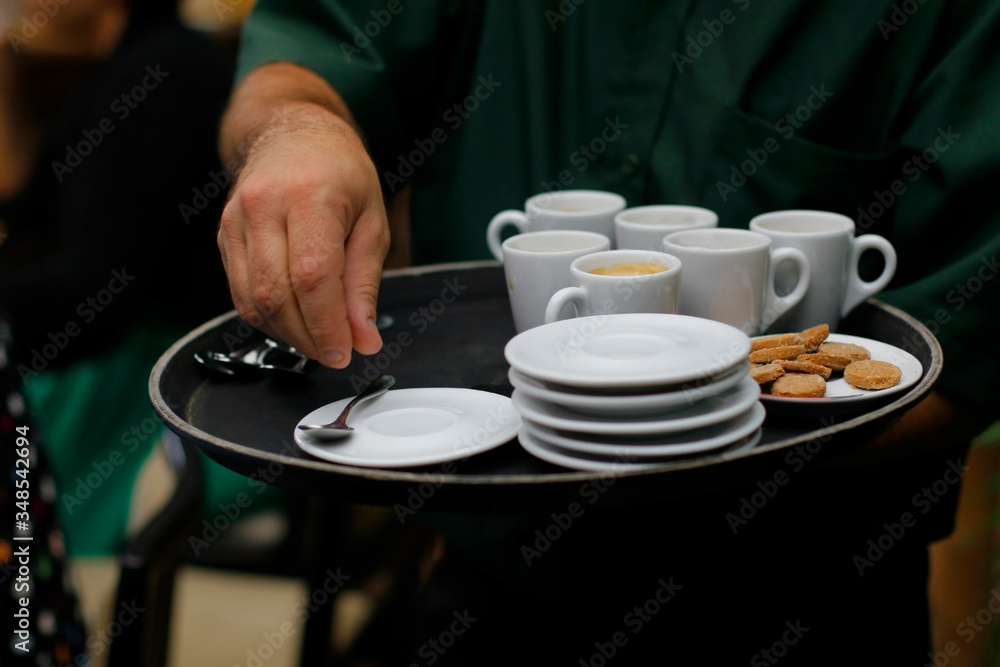 waiter serving cups of coffee, narrow focus waiter serving cups of coffee, narrow focus