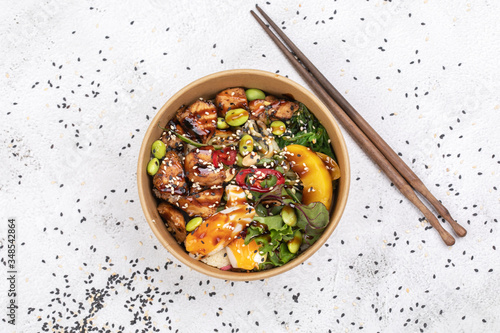 Poke bowl with chicken and vegetables on the white table. photo