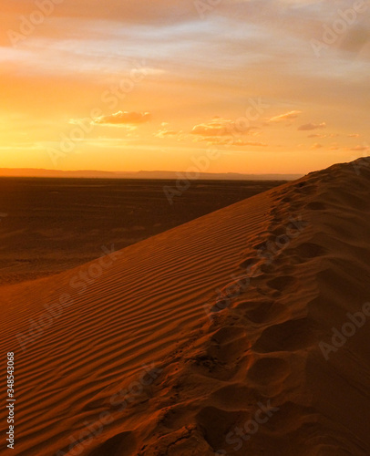 Sunset with footprints on sandy ridge