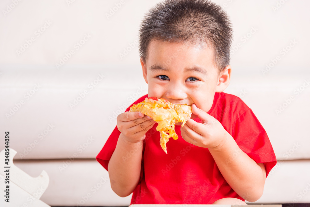 Hot Homemade, Vegetarian fast Italian food, Cute Little Child enjoying eating Delivery Pizza pepperoni, cheese many slices deliciously in an open cardboard box at home Hot Homemade, Vegetarian fast Italian food, Cute Little Child enjoying eating Delivery Pizza pepperoni, cheese many slices deliciously in an open cardboard box at home
