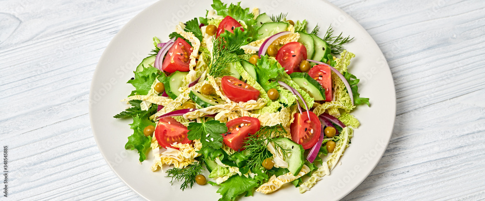 Savoy cabbage salad with cherry tomatoes, cucumeber on dish. Healthy summer salad vegetarian meal concept. Mixed leaves, tomatoes and vegetable salad on white wood, banner Savoy cabbage salad with cherry tomatoes, cucumeber on dish. Healthy summer salad vegetarian meal concept. Mixed leaves, tomatoes and vegetable salad on white wood, banner