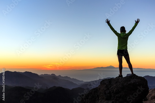 Woman climber success silhouette in mountains, achievement inspiration