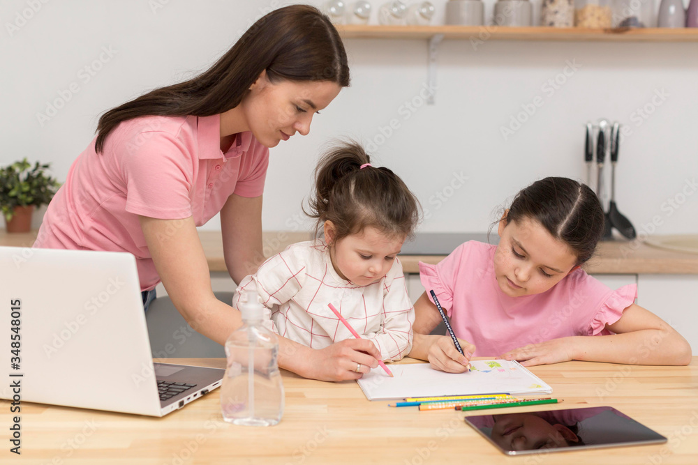 Mother and girls colouring. Isolation at home and quarantine due to coronavirus. Mother and girls colouring. Isolation at home and quarantine due to coronavirus.