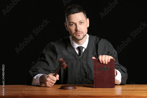 Male judge with book at tab...