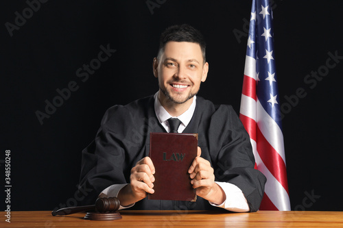 Male judge with book at tab...
