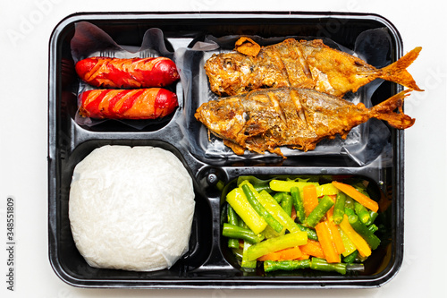 Healthy food in bento set with rice, fried fish, sausage and veggies