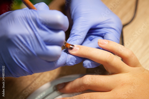 a manicurist in rubber gloves makes a manicure. nails