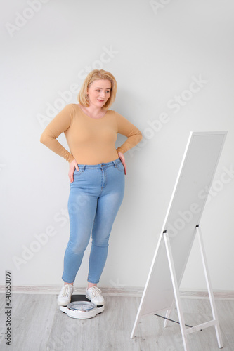 Overweight woman with scale...