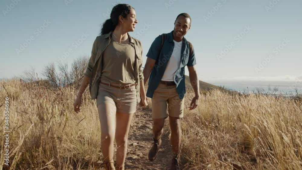 Couple trekking together on a summer vacation in the countryside. Young man and woman holding hands walking through a mountain trail.
Couple trekking together on a summer vacation in the countryside. Young man and woman holding hands walking through a mountain trail.
