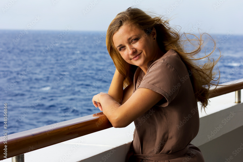 Young smiling girl on a  yacht  on the sea.The girl breathes fresh air in the open sea.