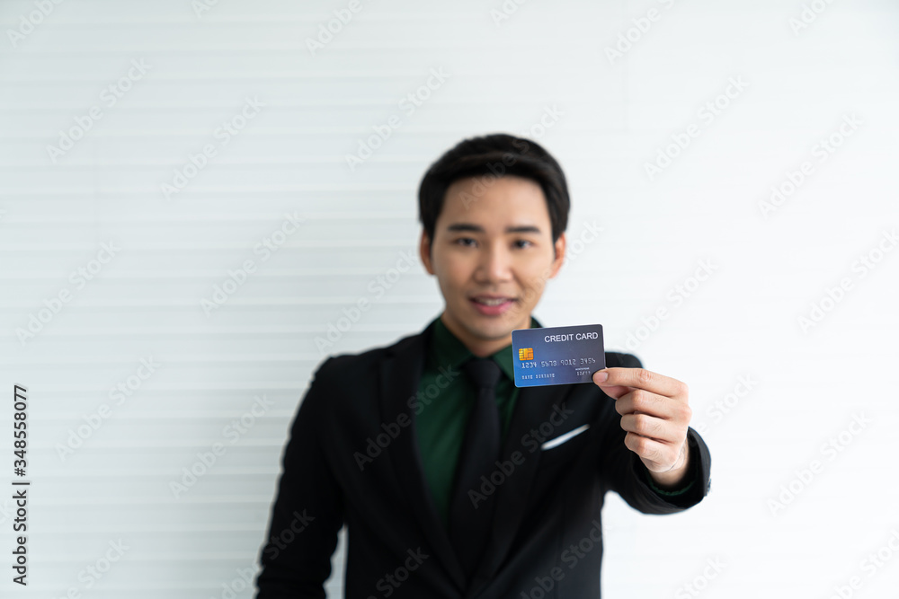 Young asian businessman holding credit card on white background / business concept / payment and expense concept / successful job. Young asian businessman holding credit card on white background / business concept / payment and expense concept / successful job.