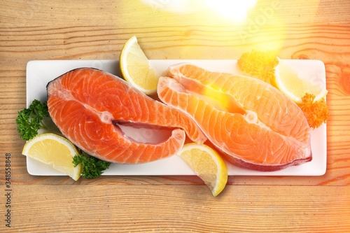 Fresh salmon steaks with parsley on white plate