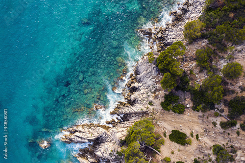 aerial top view of a clear ocean with rocky coast