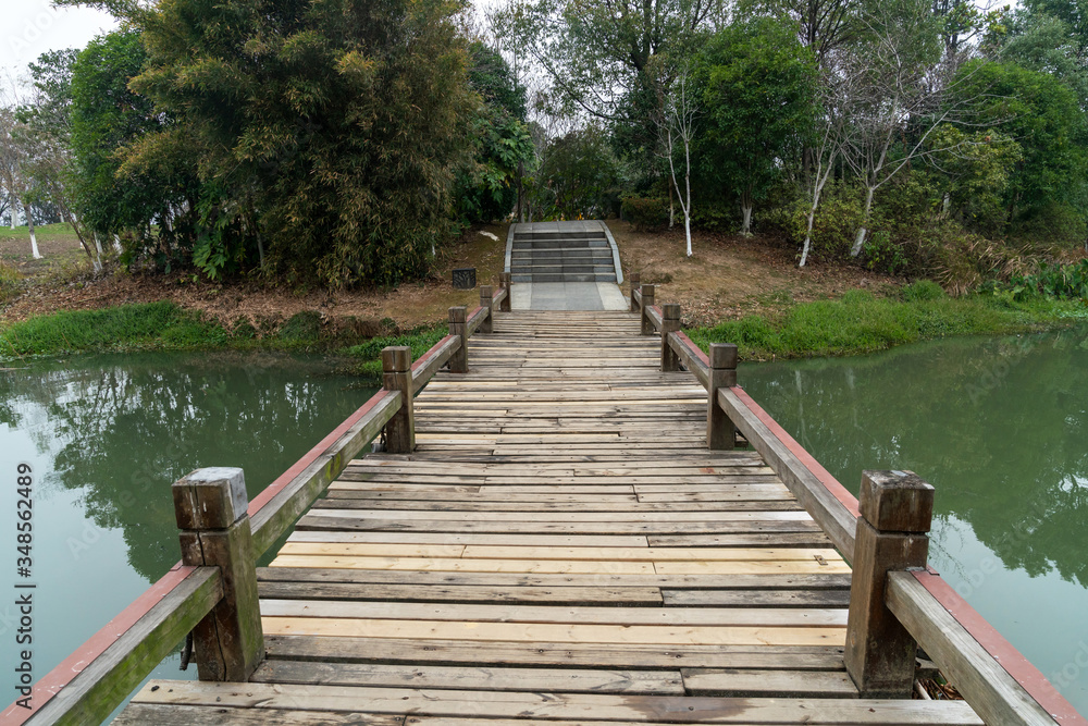 Fototapeta premium Wooden bridge over little river in city park