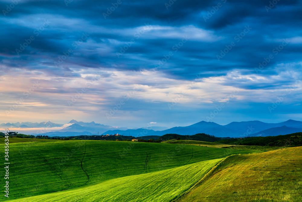 Tuscan green field and blue sky with clouds