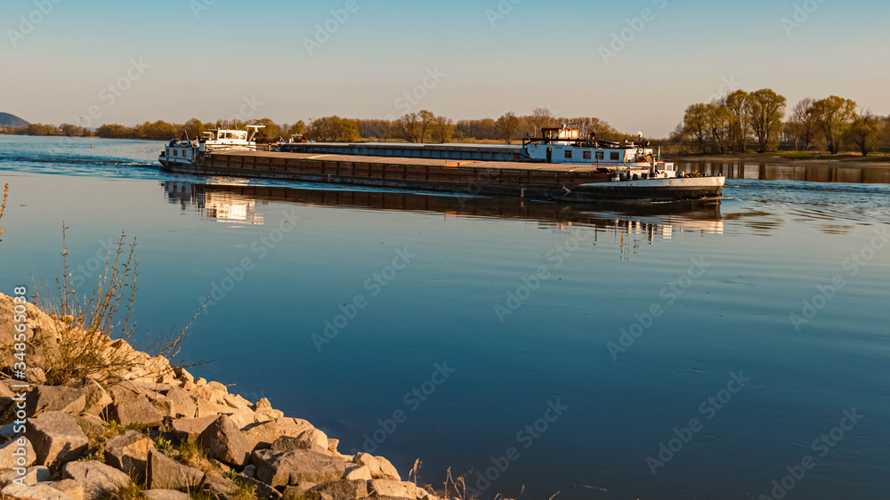 Beautiful spring view with reflections and freight ships near Metten, Danube, Bavaria, Germany