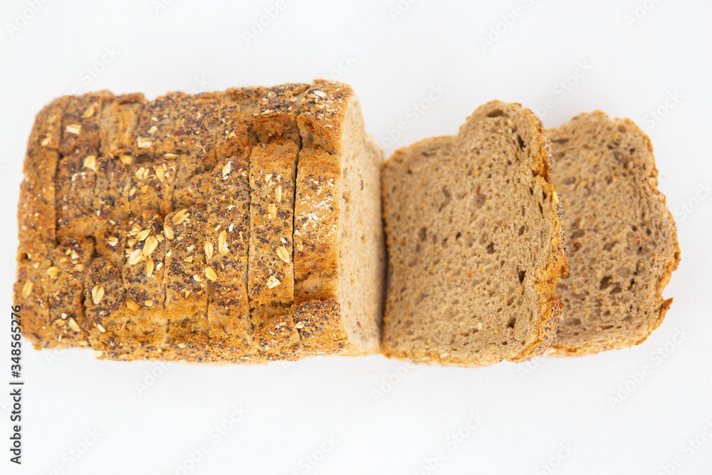 Homemade sliced cereal bread with oatmeal and seeds. Stack of brown loaf cut for sandwiches isolated on white background. Studio shot. Top view. Cooking and baking at home concept Homemade sliced cereal bread with oatmeal and seeds. Stack of brown loaf cut for sandwiches isolated on white background. Studio shot. Top view. Cooking and baking at home concept