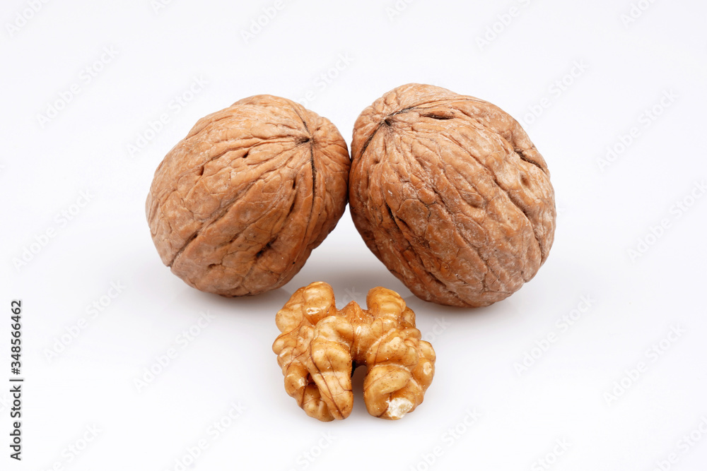 Two walnuts and walnuts with organic shell on a white background Two walnuts and walnuts with organic shell on a white background