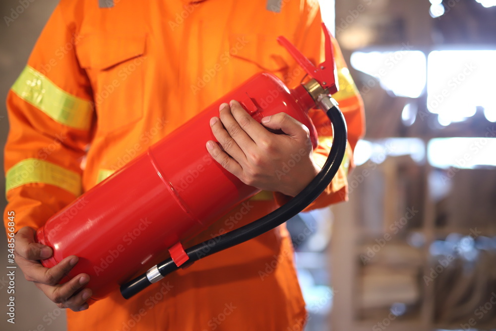 Focus on the fire extinguisher, the man carried the fire extinguisher to put out the fire in the