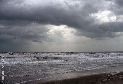Ocean with white capped rippled water and cloudy sky in early morning Florida beach.