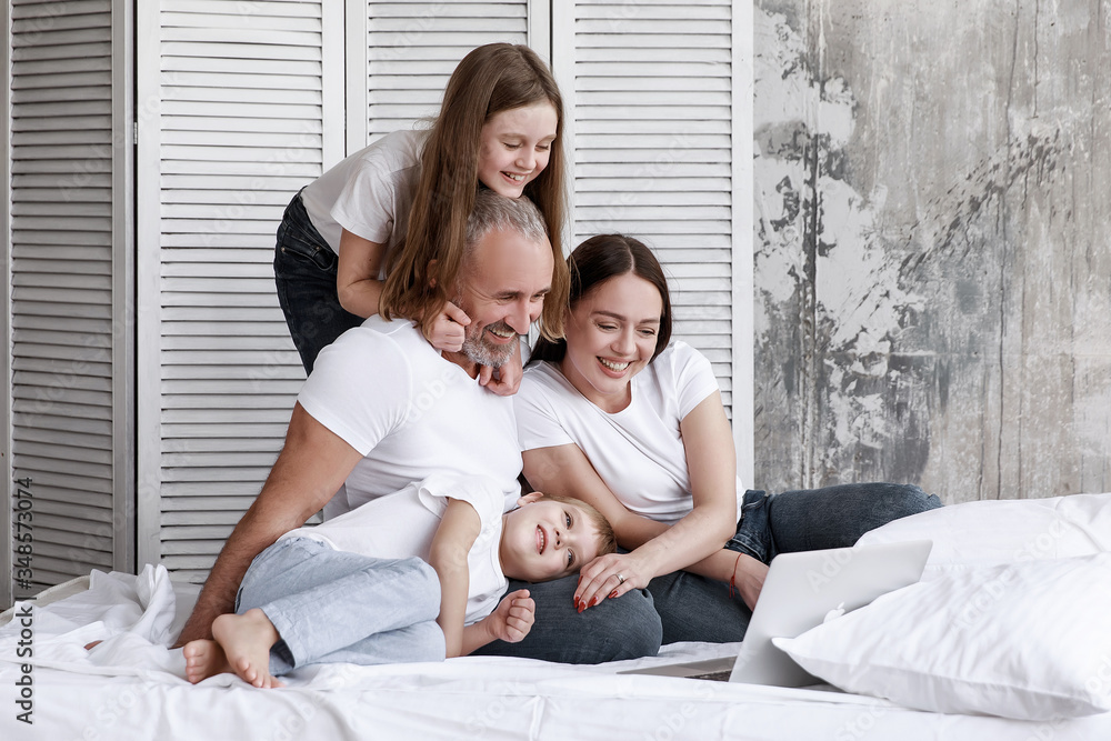 The family sits at home on self-isolation, watchmovies on a laptop, make online orders, children watch cartoons. The family sits at home on self-isolation, watchmovies on a laptop, make online orders, children watch cartoons.