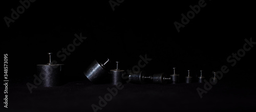 Different weights are arranged in descending order in a dark copy space background. Product photography.