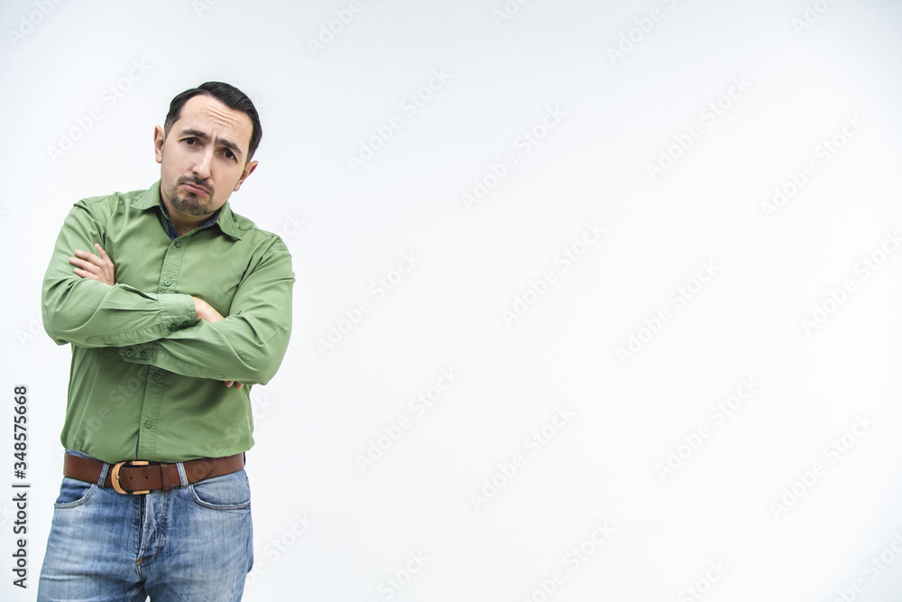 Resentful man, with arms folded, over white background looking at the camera, frowning his face. Resentful man, with arms folded, over white background looking at the camera, frowning his face.