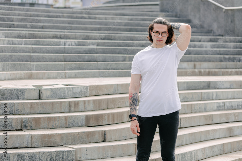 Hipster handsome male model wearing white blank t-shirt with space for your logo or design in casual urban style Hipster handsome male model wearing white blank t-shirt with space for your logo or design in casual urban style
