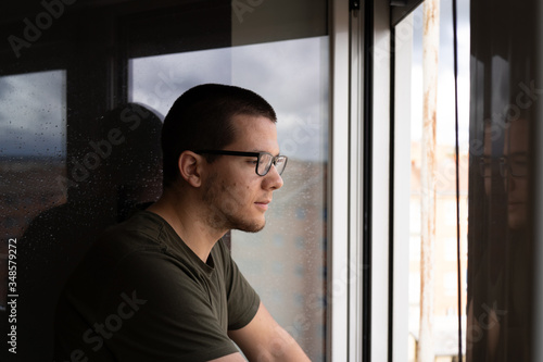 quarantined man looking out the window © Florencio
