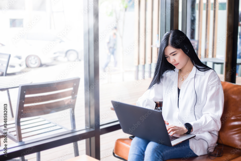 Asian businesswomen are using notebook computers and wear headphones for online meetings and working from home. Asian businesswomen are using notebook computers and wear headphones for online meetings and working from home.
