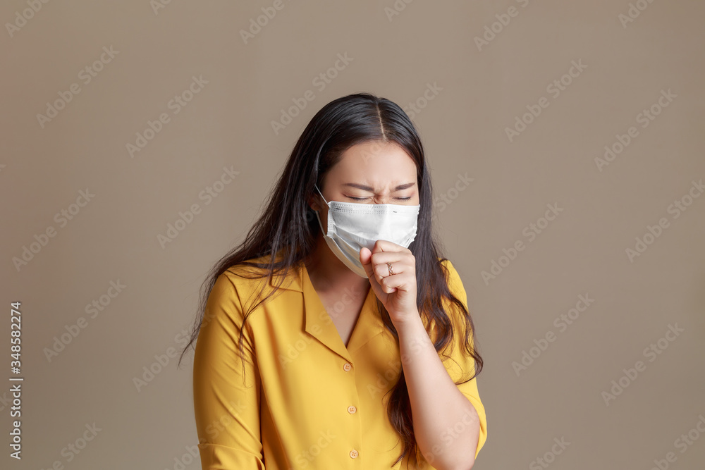 Young attractive Asian woman with yellow shirt have sore throat allergy and coughing in face mask, Sneezing and coughing spread coronavirus. Young attractive Asian woman with yellow shirt have sore throat allergy and coughing in face mask, Sneezing and coughing spread coronavirus.