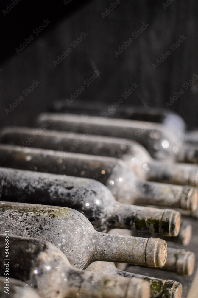 Very old stacked wine bottles closeup