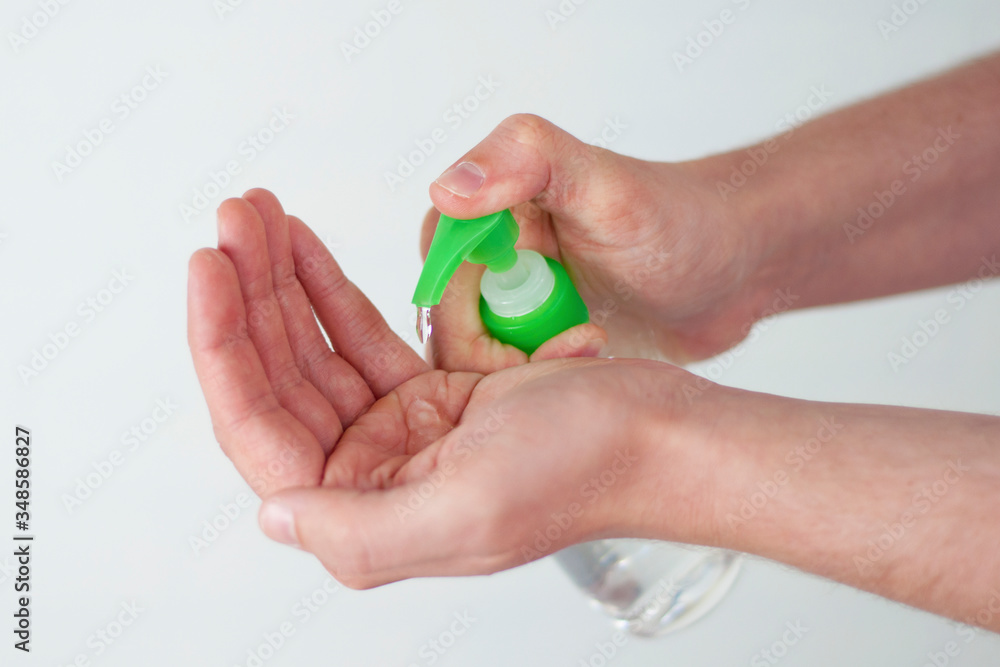An alcohol sanitizer flows to a person’s hands to disinfect the skin. Selective focus An alcohol sanitizer flows to a person’s hands to disinfect the skin. Selective focus