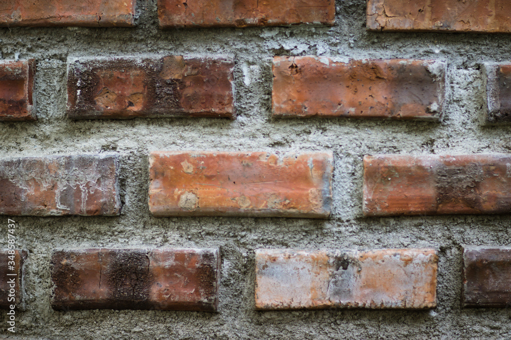 Fototapeta premium Close-up details of a orange-brown brick wall. red brick wall close up, old brick background. red brick wall. vintage style.