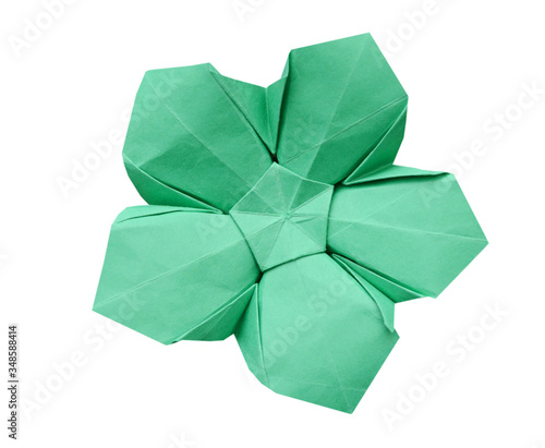 Green paper origami flower on wooden background