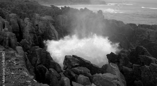 The sea crash into the blowhole of Pancake Rocks, New Zealand. Black and white photo