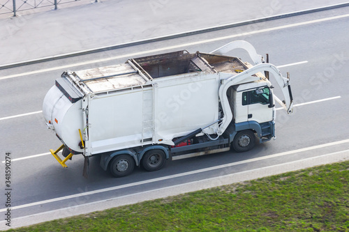 Obraz na plátně Truck for waste collection in residential areas of the city rides on the road