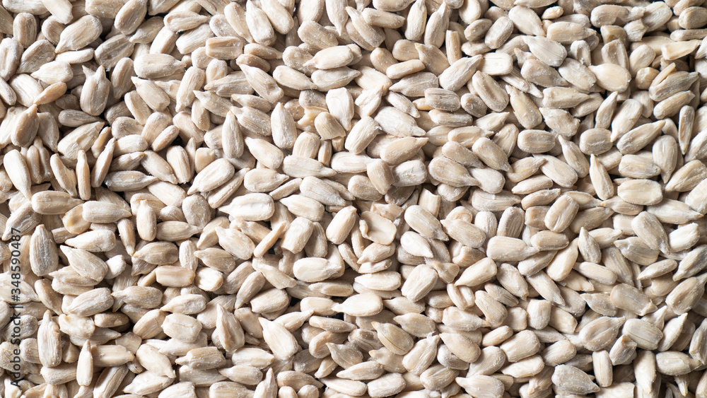 Scattered peeled sunflower seeds as background. Shelled sunflower seeds texture. Top view sunflower seeds closeup Scattered peeled sunflower seeds as background. Shelled sunflower seeds texture. Top view sunflower seeds closeup