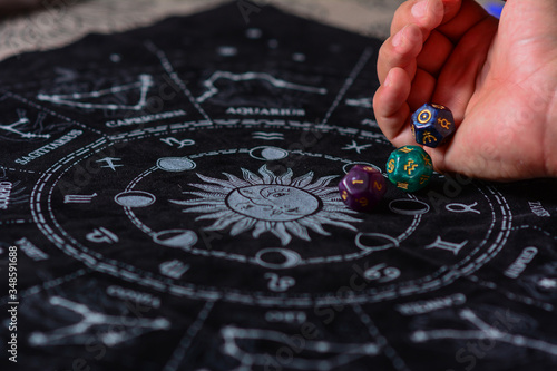 Tablou pe pânză Male Hand with esoteric dices and astrological symbols over tarots cards like a