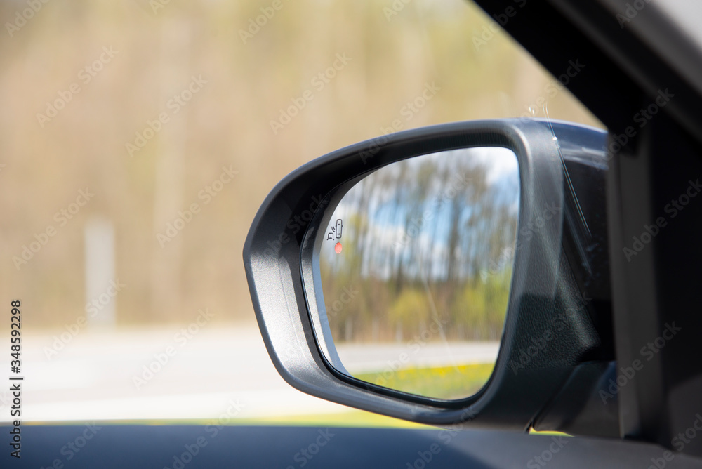 blind zone monitoring sensor on the side mirror of a modern car