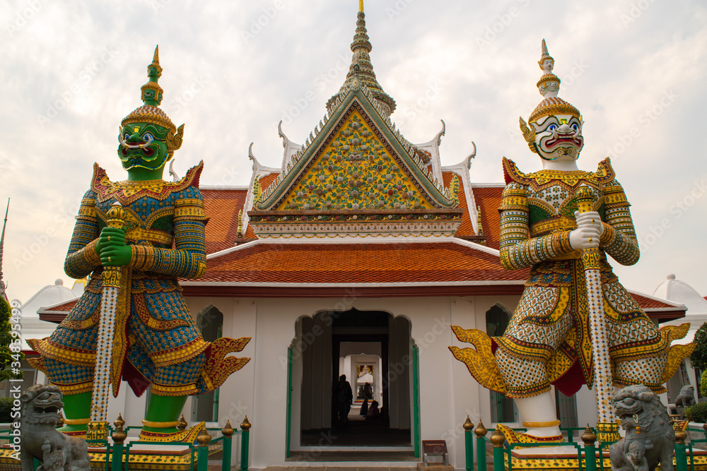 Giant statues of warriors at the entrance of the Wat Arun temple in Bangkok