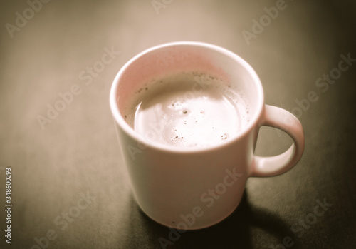 cup with cappuccino on a wooden background
