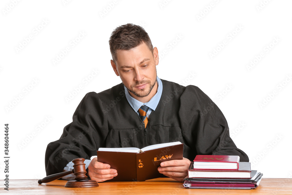 Male judge reading book at table on white background Male judge reading book at table on white background