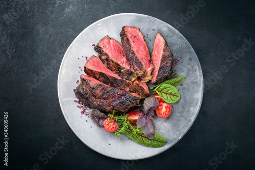 Gegrilltes dry aged Wagyu Entrecote Steak vom Rind mit Salat und Tomaten als Draufsicht auf einem Modern Design Teller mit Textfreiraum photo